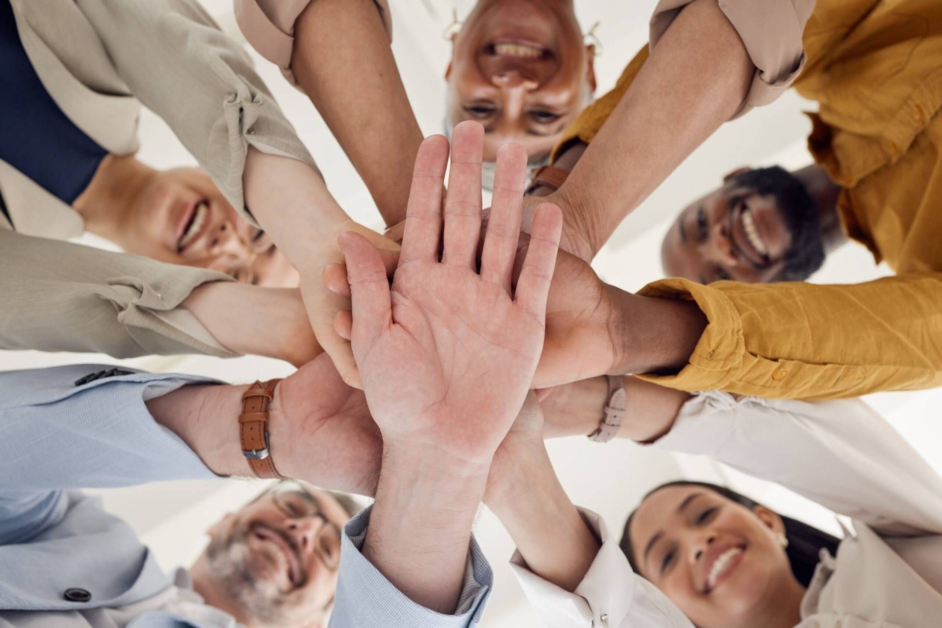 Mani di un gruppo di persone unite in segno di collaborazione e lavoro di squadra